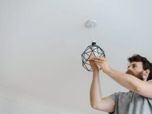 hombre realizando instalación de lampara en el techo
