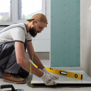 Especialista realizando trabajos de remodelación de baños en un espacio moderno con enchapes, sanitarios y acabados renovados