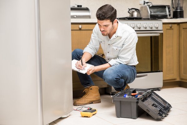 Especialista realizando el diagnóstico de un refrigerador para su reparación- AYDA