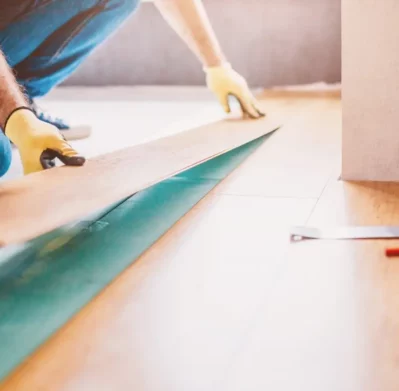 Personal de AYDA realizando instalación de piso laminado