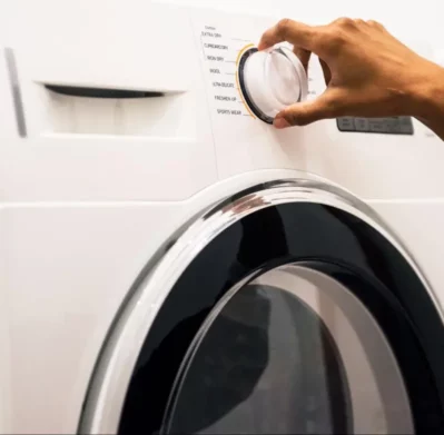 Lavadora blanca con perilla frontal en zona de lavado