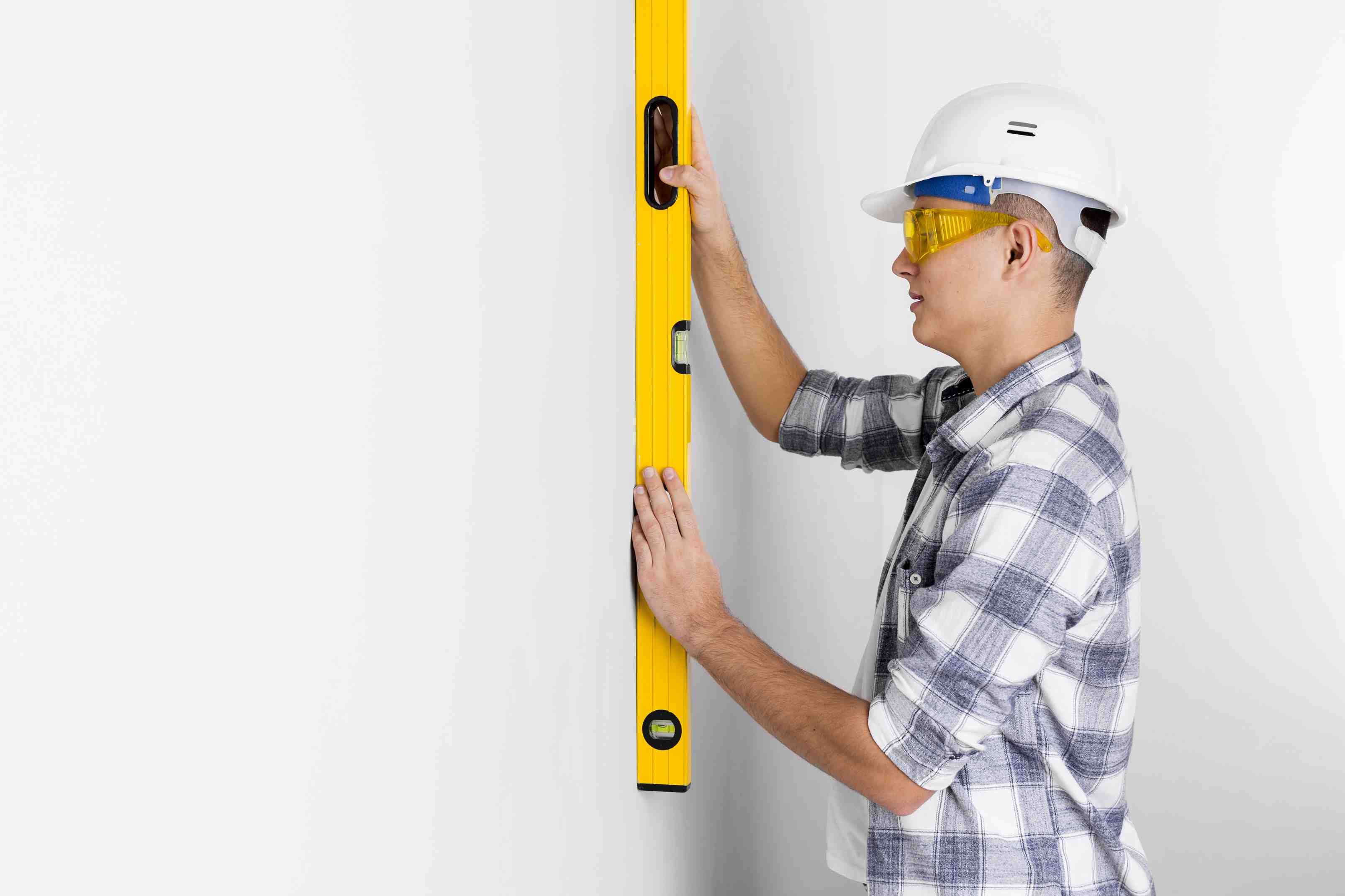 Trabajador de construcción verificando nivel de pared - AYDA