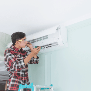 Experto realizando un mantenimiento al aire acondicionado