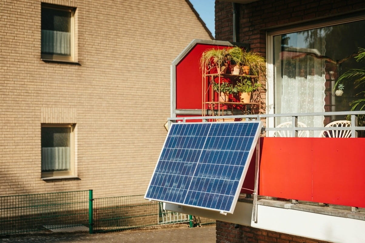 Paneles de energía solar sobre balcón de una vivienda para mejorar la eficiencia energética del hogar 