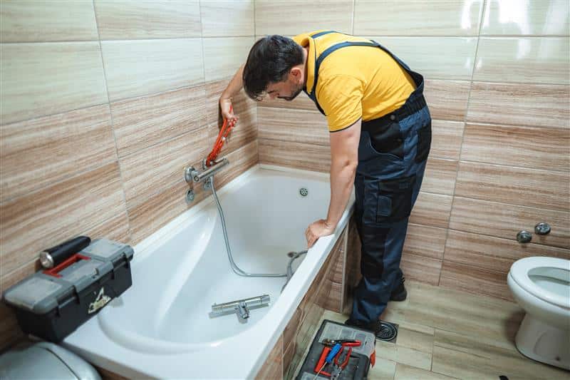 Instalación de bañera por un profesional en un baño elegante y moderno