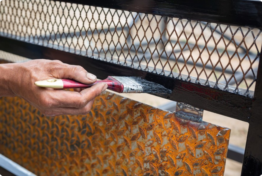 Técnico aplicando pintura protectora en reja AYDA