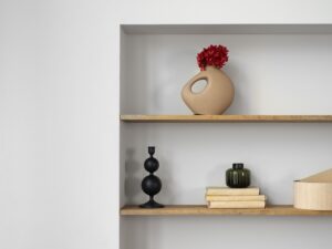 Instalación de repisas en Bogotá con decoraciones de libros y objetos en pared blanca