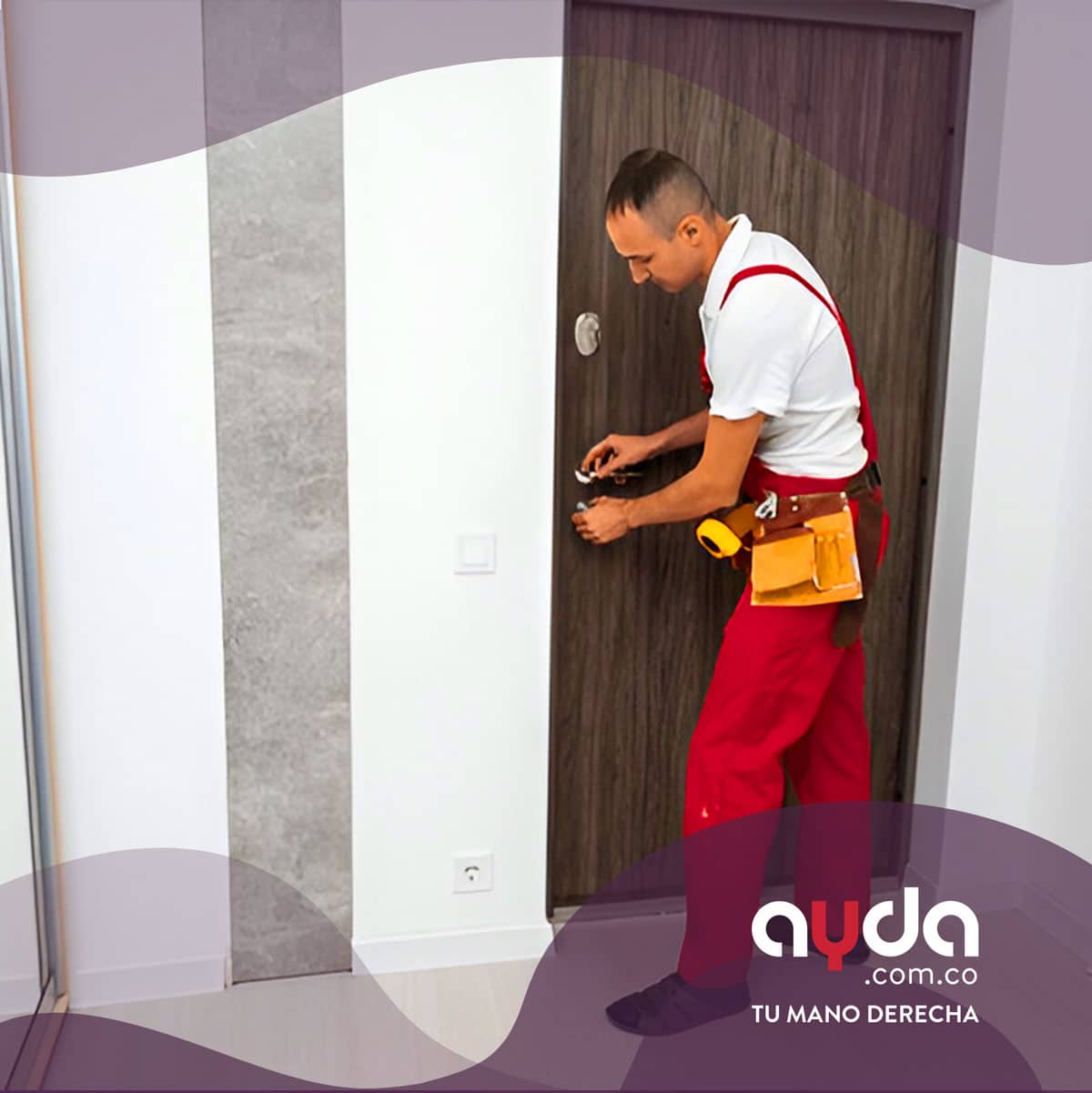 Cerrajero en uniforme rojo y blanco realizando el arreglo de cerradura de la puerta de madera con cinturón de herramientas