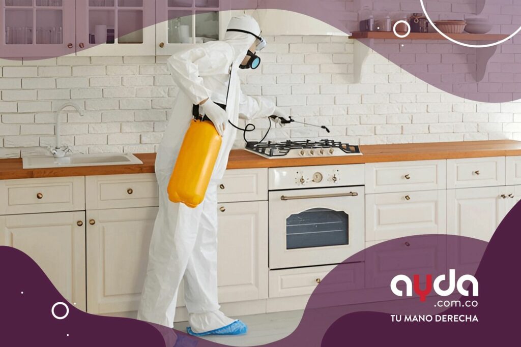 Hombre fumigando cocina para eliminar las cucarachas Un profesional con traje de protección blanco, gafas y mascarilla fumiga la estufa en una cocina blanca para eliminar las cucarachas