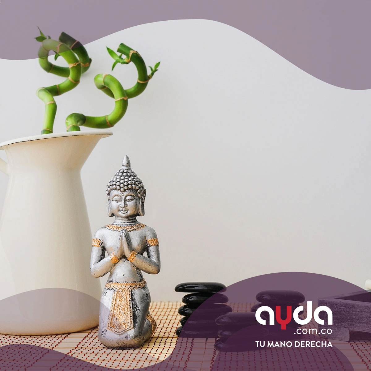 Una estatua de Buda de piedra, rodeada de plantas en un florero y piedras negras, como elemento decorativo de feng shui en casa