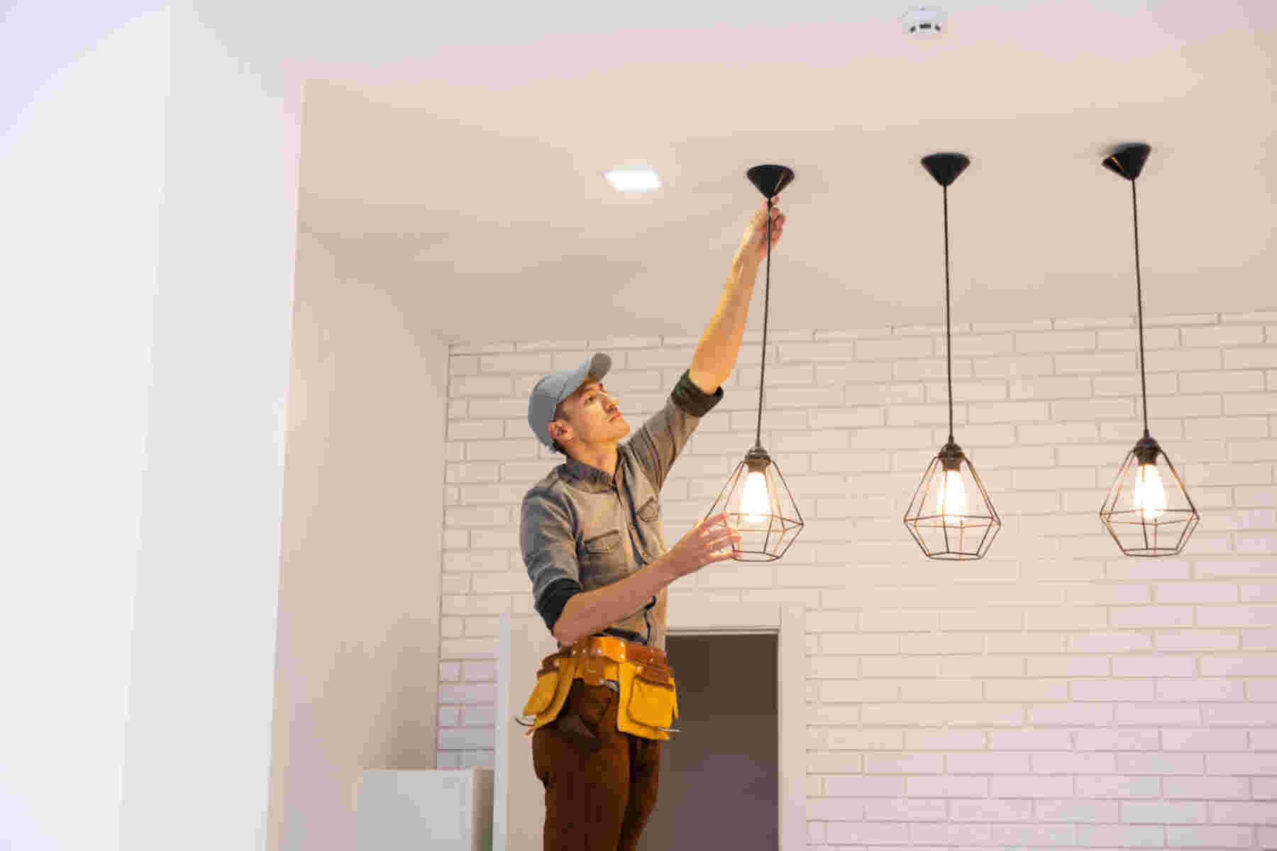 Técnico electricista instalando luminarias colgantes-AYDA