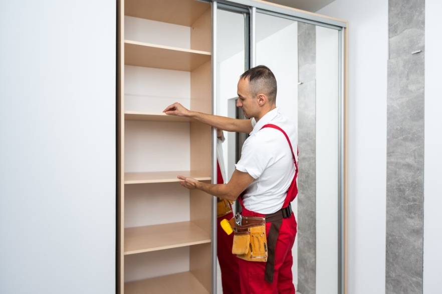 Un técnico especializado realizando el ensamblaje del marco de un armario como parte del servicio de armado de closet en un hogar